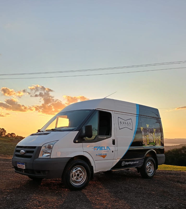 Van branca com envelopamento visual da Gallia Gourmet ao pôr do sol
