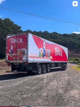 Carreta vermelha com comunicação visual aplicada